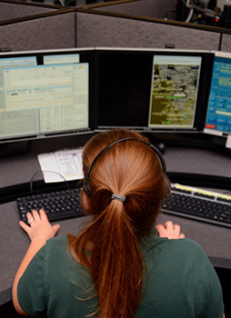 Communications aide sitting behind computer